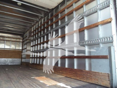 Mack MD7 truck interior cargo area with wooden side support rails and metal wall studs.