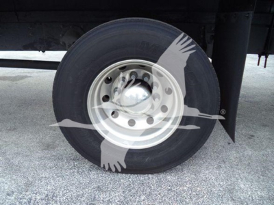 Dually wheel/tire on Mack MD7 truck chassis showing steel rim and tire tread with hubcap and mudflap.