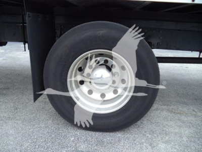 Truck wheel and tire on Mack MD7 chassis showing single rear wheel with steel hub and dual rear axle? image shows wheel with hubcap and black tire; partial undercarriage visible.