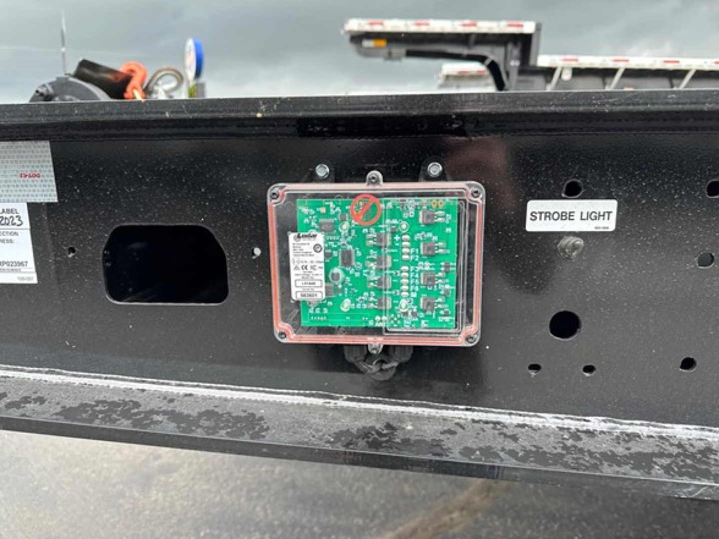 Trailer frame with green circuit panel labeled Strobe Light and various stickers and labels visible.