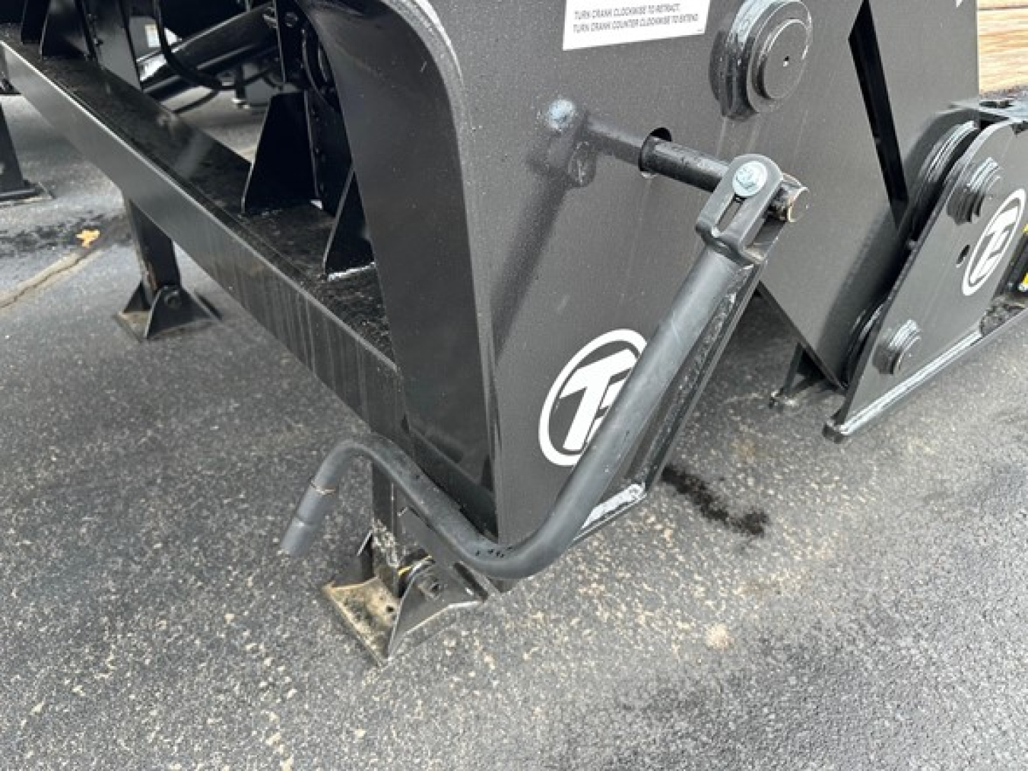 Trail-Eze TE801 trailer hitch and frame view showing hydraulic or torsion linkage and metal jack stand with label, black powder-coated steel.