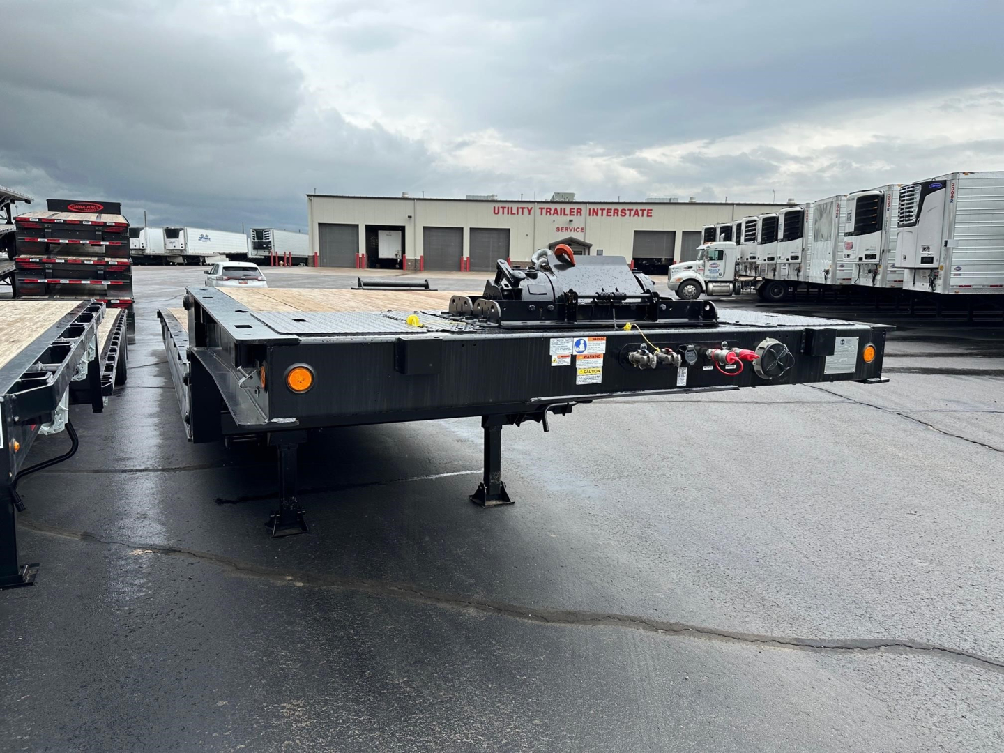 Trail-Eze TE801 travel trailer flatbed trailer front with hitch and hydraulic system showing labels and safety chains.