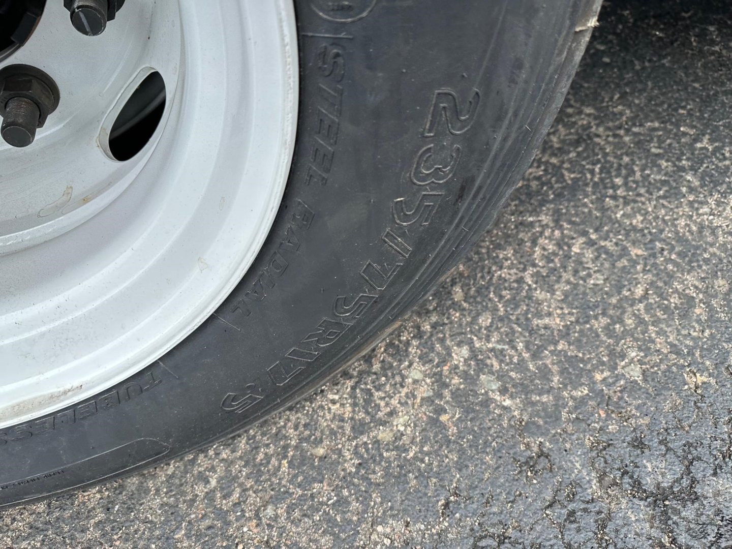 Trail-Eze Te801 trailer wheel with tire showing 235/75R... and silver rim, partial view of hub and lug holes.