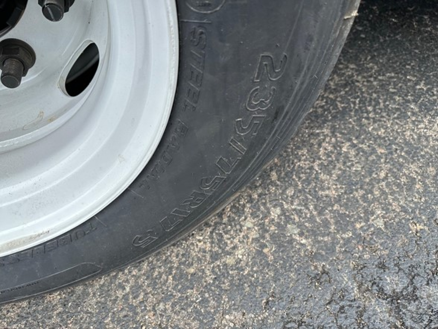 Trail-Eze trailer wheel and tire close-up showing tire sidewall with '23.5 R' marking and white steel rim.