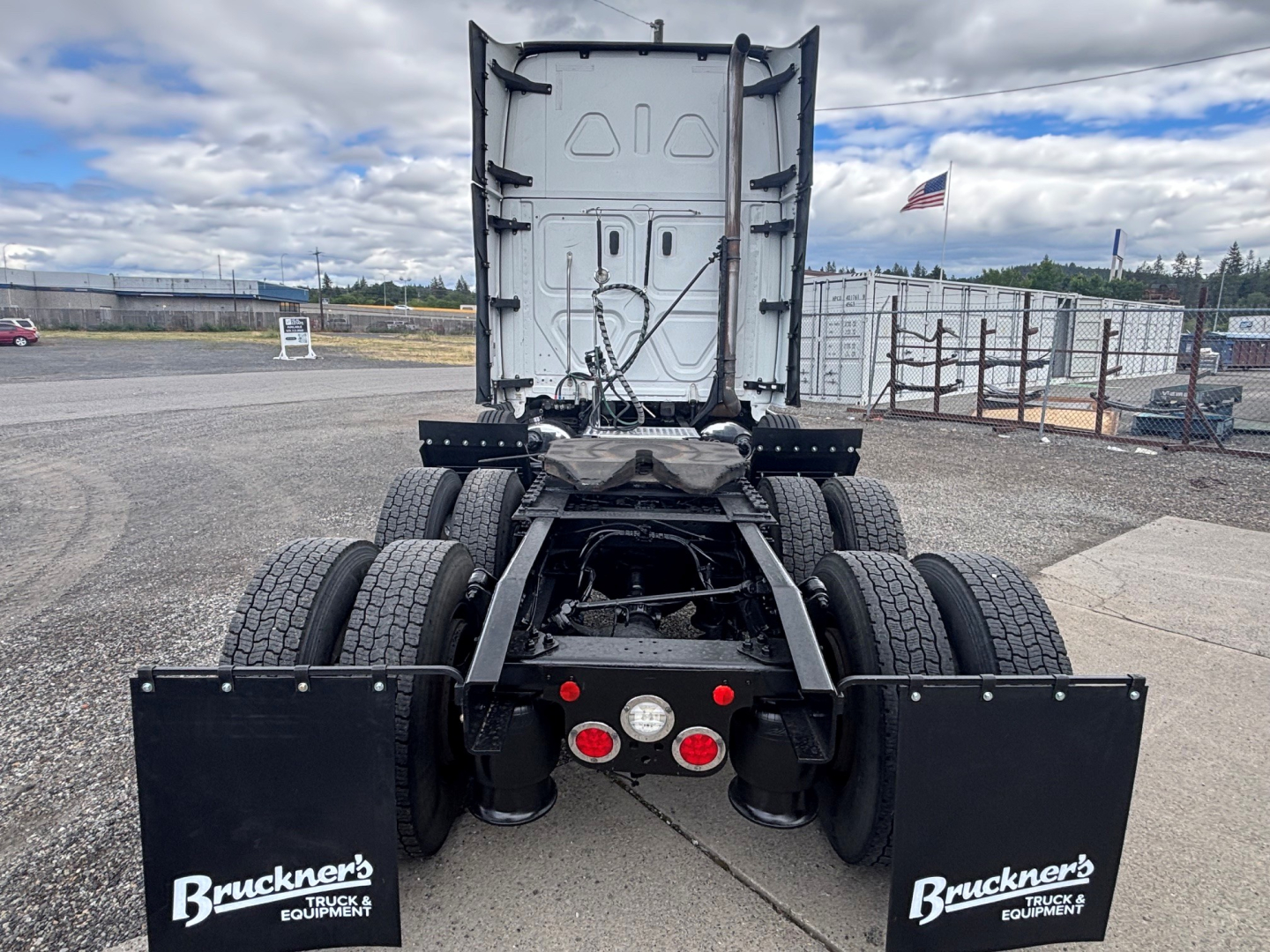 Freightliner CA-126 tractor rear view showing dual rear axles and mud flaps with Bruckner's Truck & Parts logos; empty fifth wheel and vertical exhaust area visible; license plate area not present.