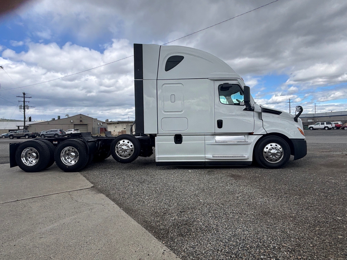 Freightliner CA-126 tractor side view showing sleeper cab, white exterior, dual rear axles, and chrome wheels; no visible damage text present.