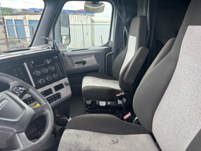 Freightliner CA-126 truck cab interior showing driver and passenger seats, steering wheel, dashboard with gauges, and center console.