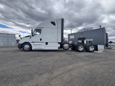 Truck cab and dual rear axle tractor from a Freightliner CA-126, white cab with sleeper, side view showing fuel tanks and chassis.