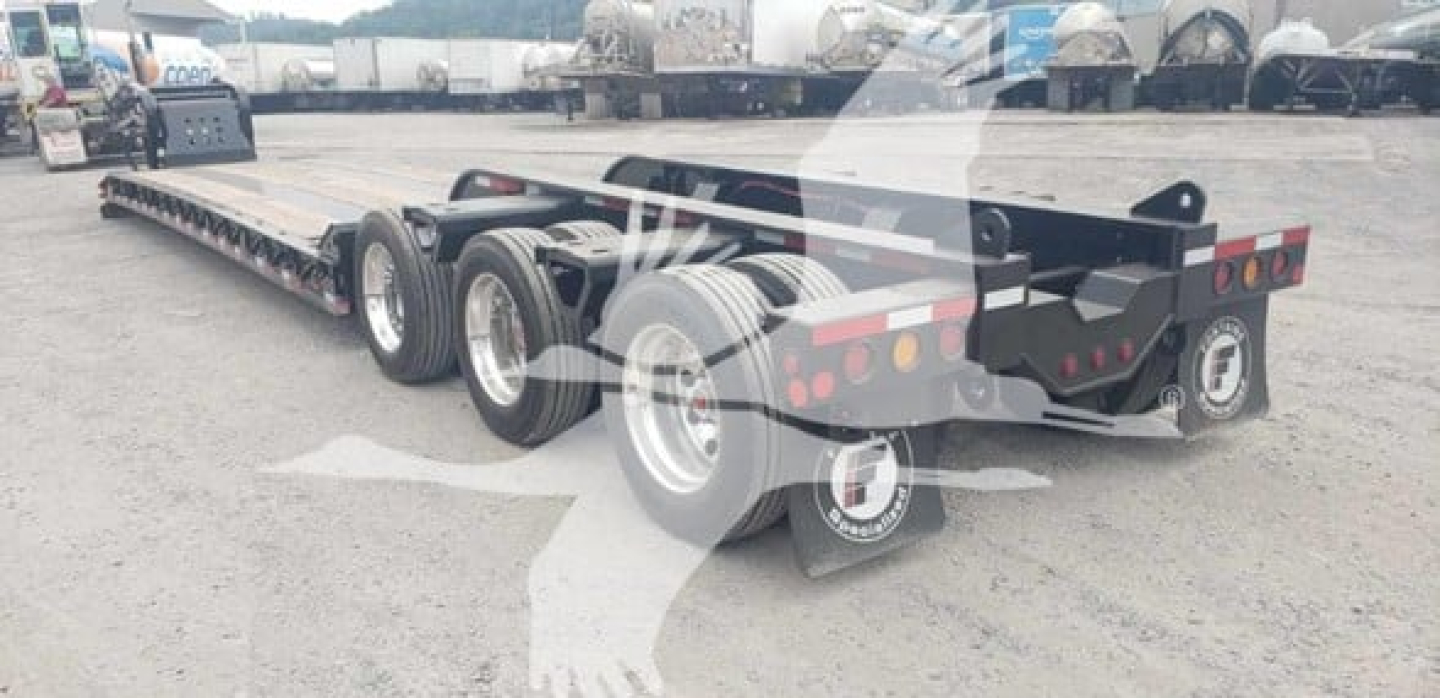 Fontaine 55Mxt lowboy trailer showing long multi-axle chassis, tandem rear axles, and rear lamps with reflective tape.