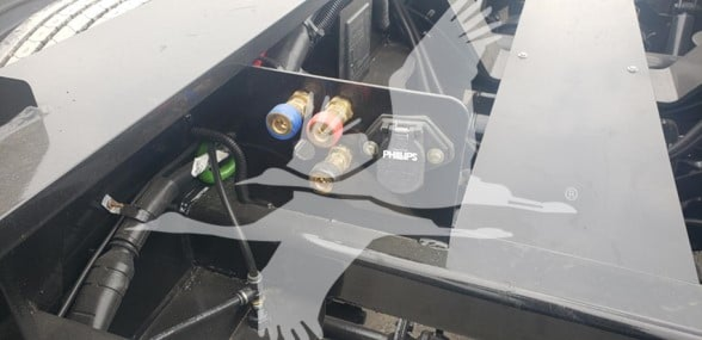 Trailer back-end with hydraulic hoses and disconnects showing coupling valves and Philips component label.