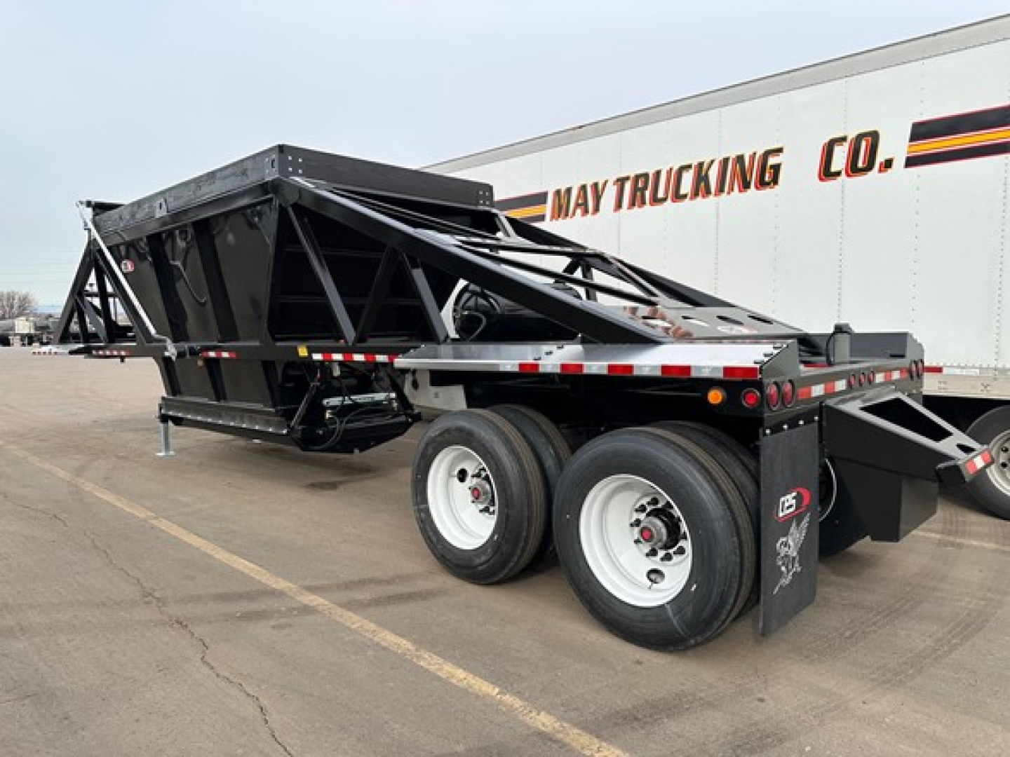 Trailer showing bottom-dump frame with dual rear axles and hydraulic components, CPS air ride light weight bottom dump.