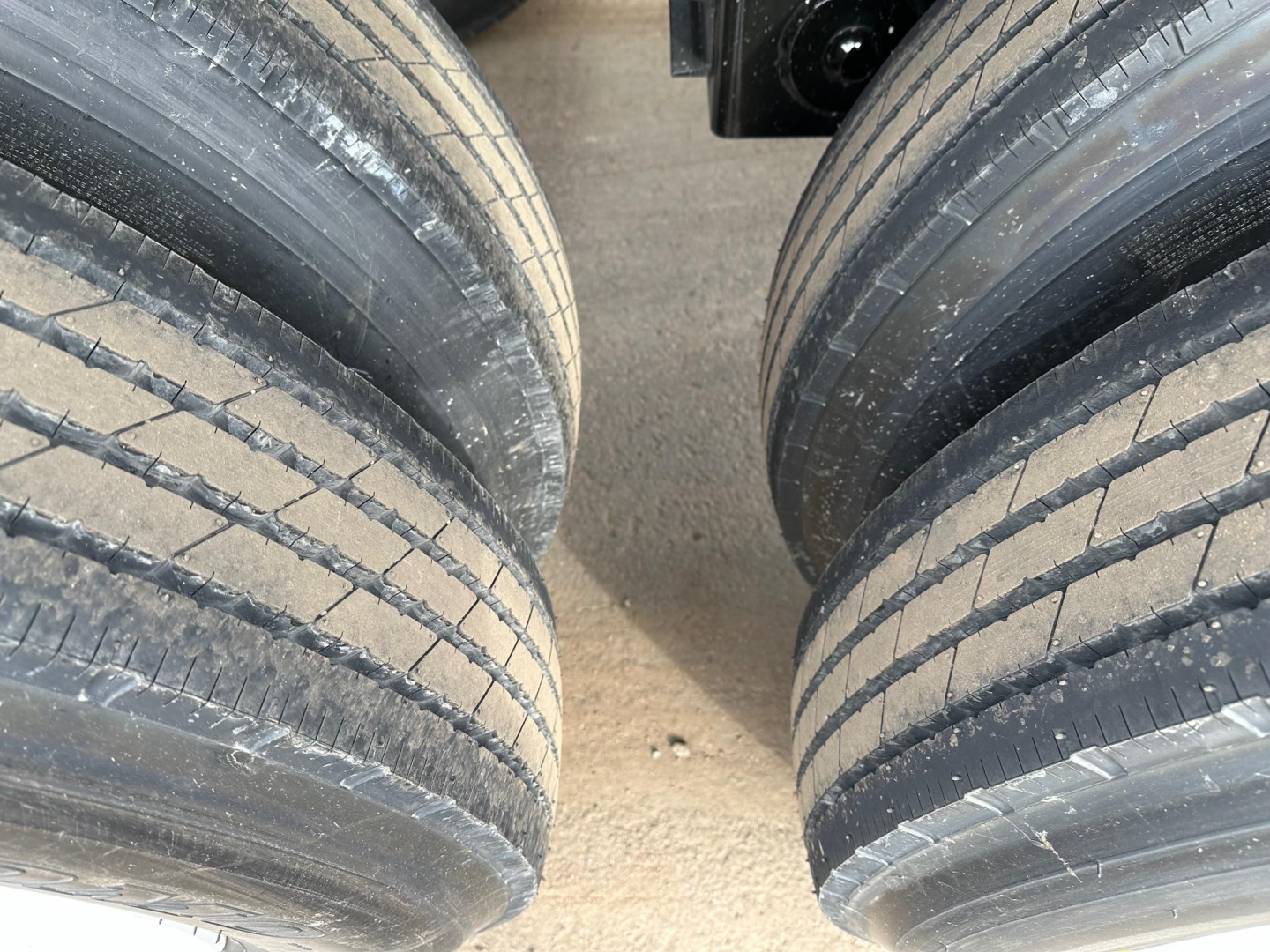 Bottom dump trailer tires and suspension visible; no labeling or text readable; part appears unused for heavy hauling.