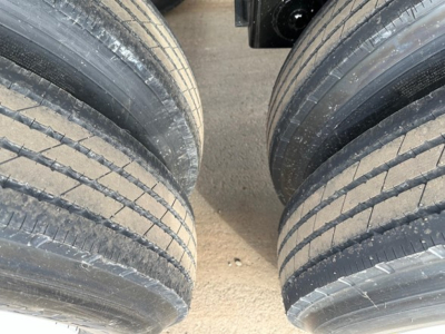 Lightweight bottom dump trailer wheels close-up view showing dual tire arrangement and tread details.