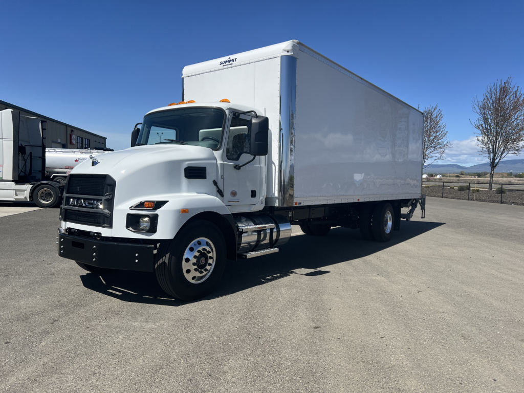 Mack MD6 box truck in a parking lot showing side of large white cargo box and front grille with Mack logo.