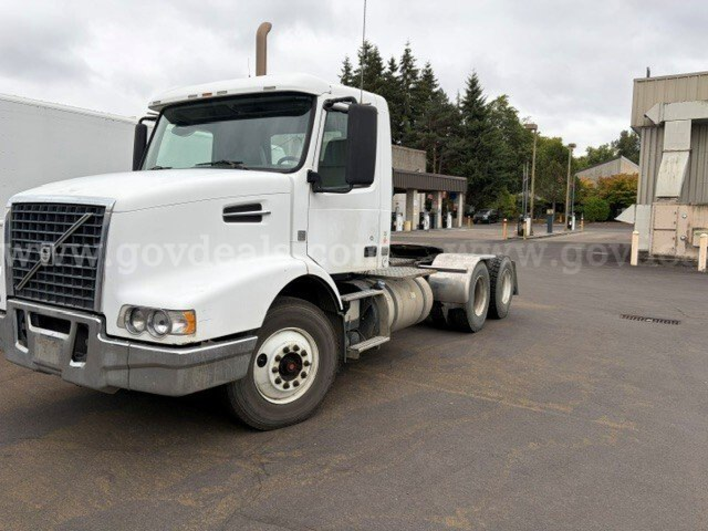 Volvo VHD truck in inventory listing showing cab, front grille, and chassis with bare flatbed area.