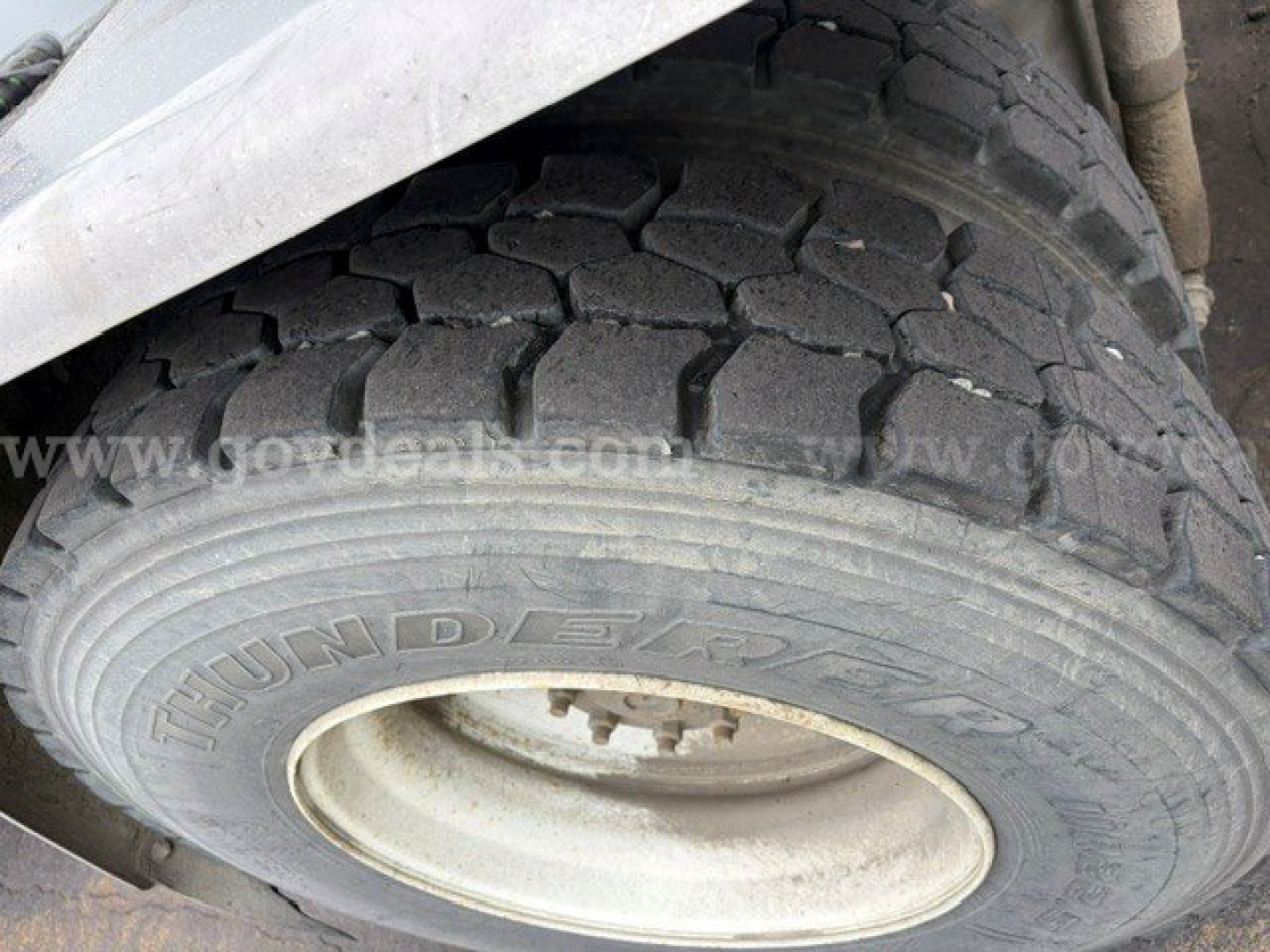 Truck wheel and tire showing tread pattern and hubcap with 'DUN...' visible on tire sidewall.