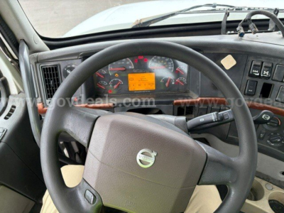 Volvo VHD steering wheel and dashboard view showing orange warning label on instrument cluster and circular gauges.