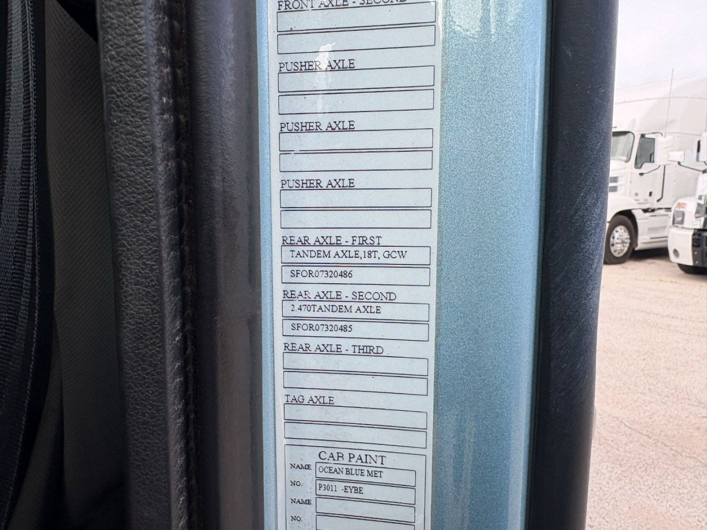 Label plate on Volvo VNL64T760 door frame showing axle ratings and car paint details.