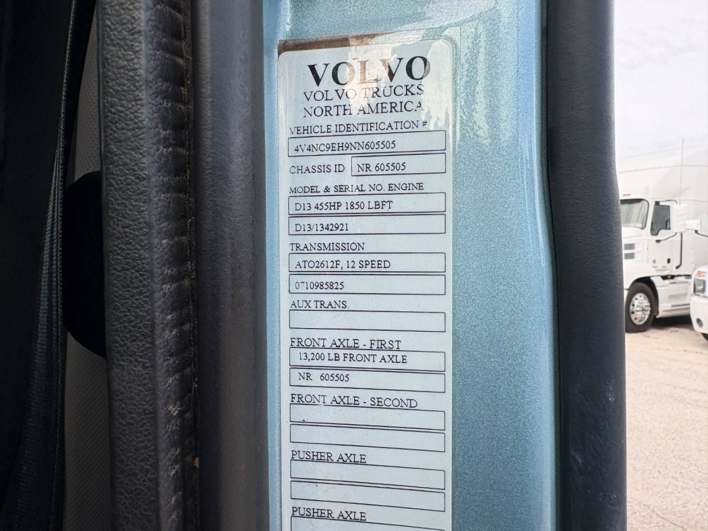 Volvo Trucks North America vehicle identification plate on a blue door frame showing VIN and various chassis and axle details.