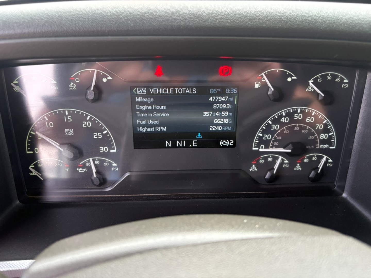 Dashboard of a Volvo VNL64T760 showing vehicle total readouts on a center display including mileage and hours.