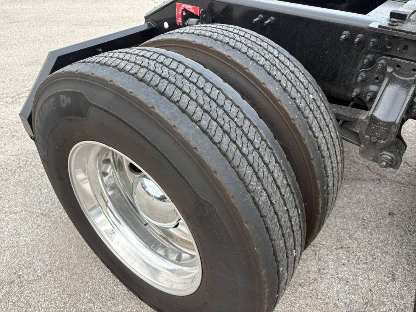 Volvo VNL64T760 tractor axle with dual rear tires and chrome wheel showing chassis components.