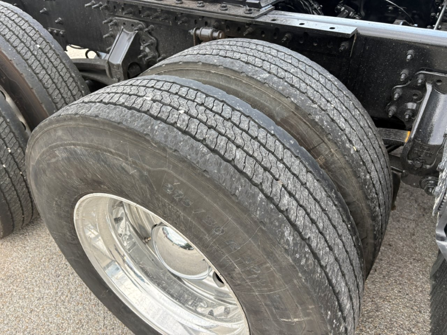Truck axle with dual rear wheels and tire treads visible.