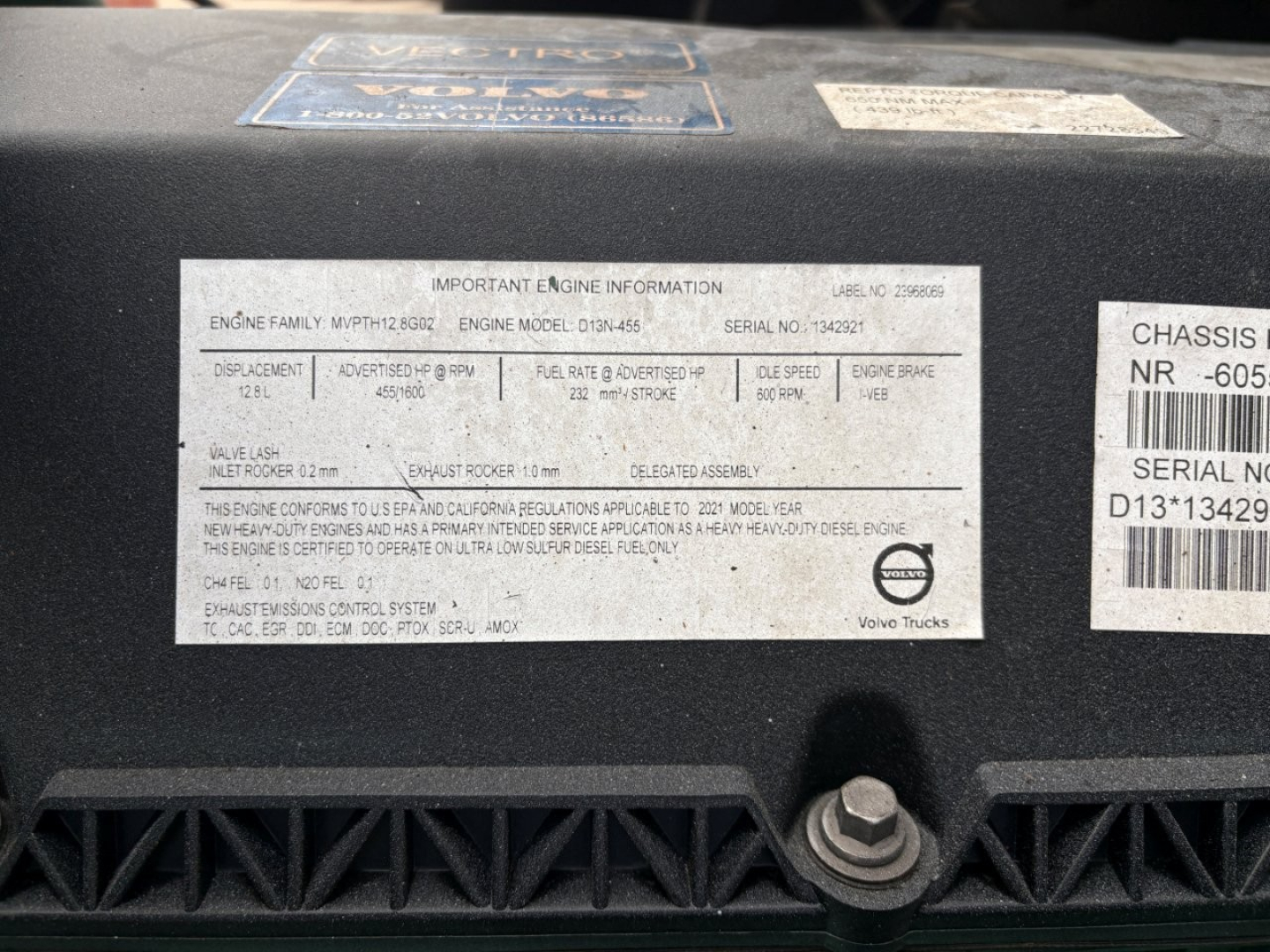 Label on Volvo VNL64T760 engine area showing engine family and model information plate with serial numbers and vehicle details.