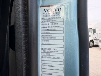Volvo Trucks North America vehicle identification plate on a blue door frame showing VIN and various chassis and axle details.