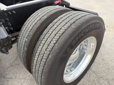 Dual rear wheels with Michelin tire brand on heavy-duty Volvo VNL64T760 truck chassis showing duals and alloy wheel.