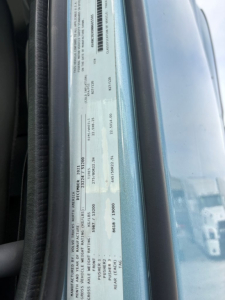 Vehicle information label on Volvo truck door jamb showing VIN, stock number, and manufacture details.