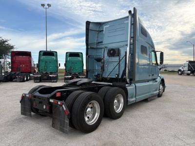 Volvo VNL64T760 tractor truck rear and cab side showing blue-gray paint, sleeper cab, dual rear axles, fifth-wheel and mudflaps visible