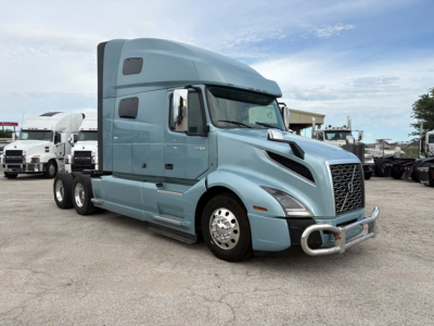 Volvo VNL64T760 truck in blue, side view showing sleeper cab and front grille.