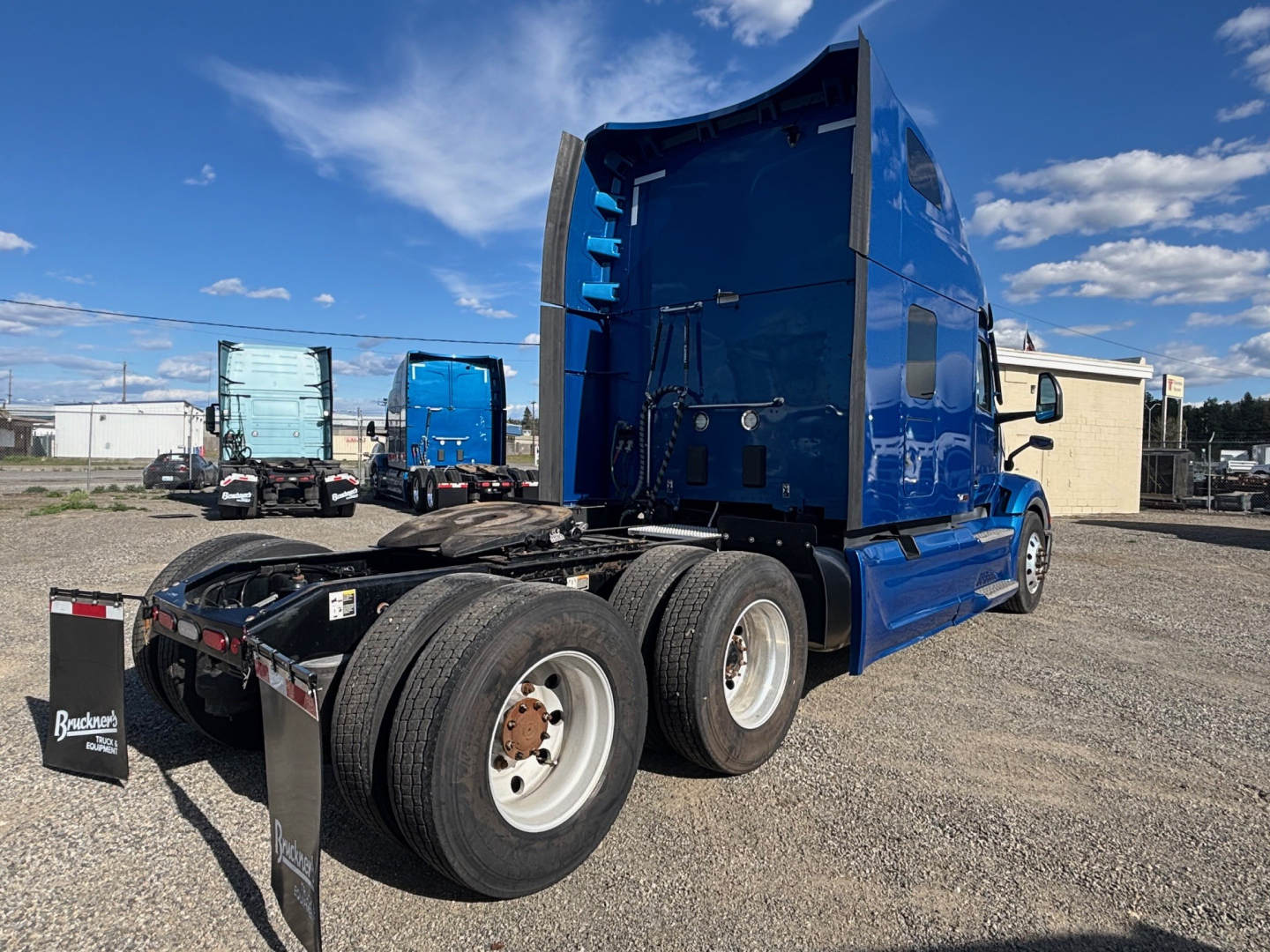 Peterbilt 579 conventional sleeper tractor in blue, rear view showing dual rear axles and cab
