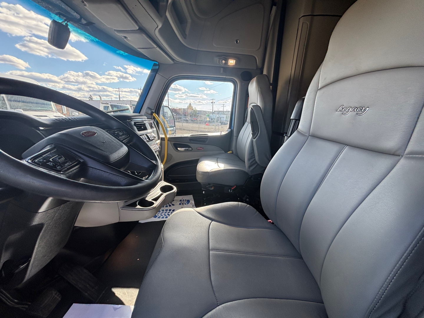 Peterbilt 579 truck interior showing driver seat and dash with steering wheel and instrumentation.