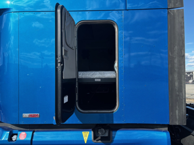 Peterbilt 579 sleeper cab rear door open showing interior bunk area in blue truck