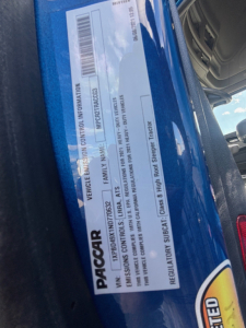 Peterbilt 579 VIN/SAFETY label close-up showing vehicle information and serial numbers on a blue truck door jamb.