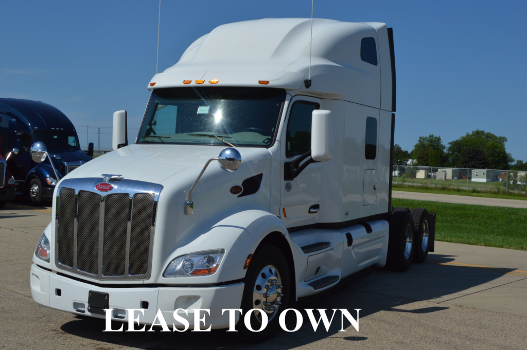Peterbilt 579 semi-truck tractor in white, front-left view showing large grille and side mirrors.