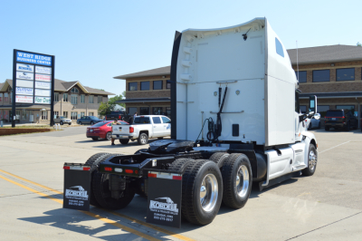 Peterbilt 579 tractor rear view showing fifth wheel and dual rear axles with white sleeper cab, no visible text on trailer.