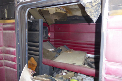 Interior cab of a 1988 Peterbilt 379 showing clutter and debris with pink interior panels and exposed metal framework.