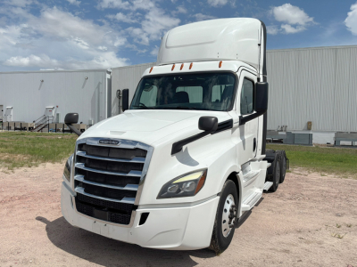 Truck cab showing Freightliner cascadia 126 with white exterior, front grille, and daylight cab in a lot.