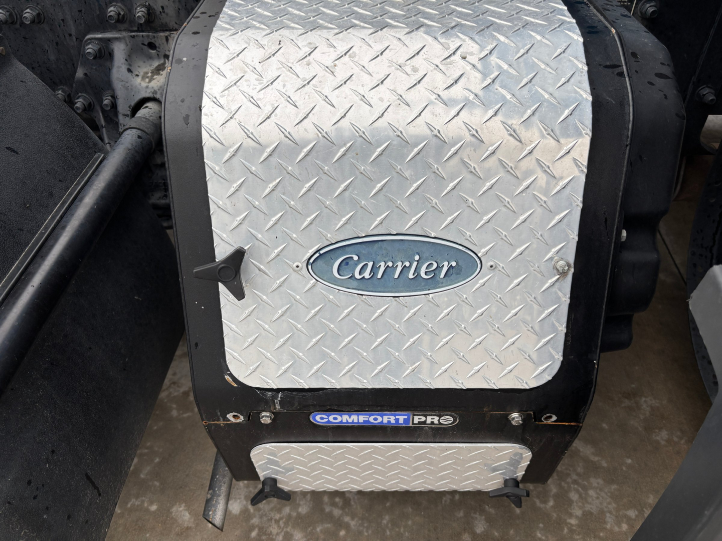 Commercial truck step area with diamond plate cover and Carrier badge; Comfort Pro label visible.