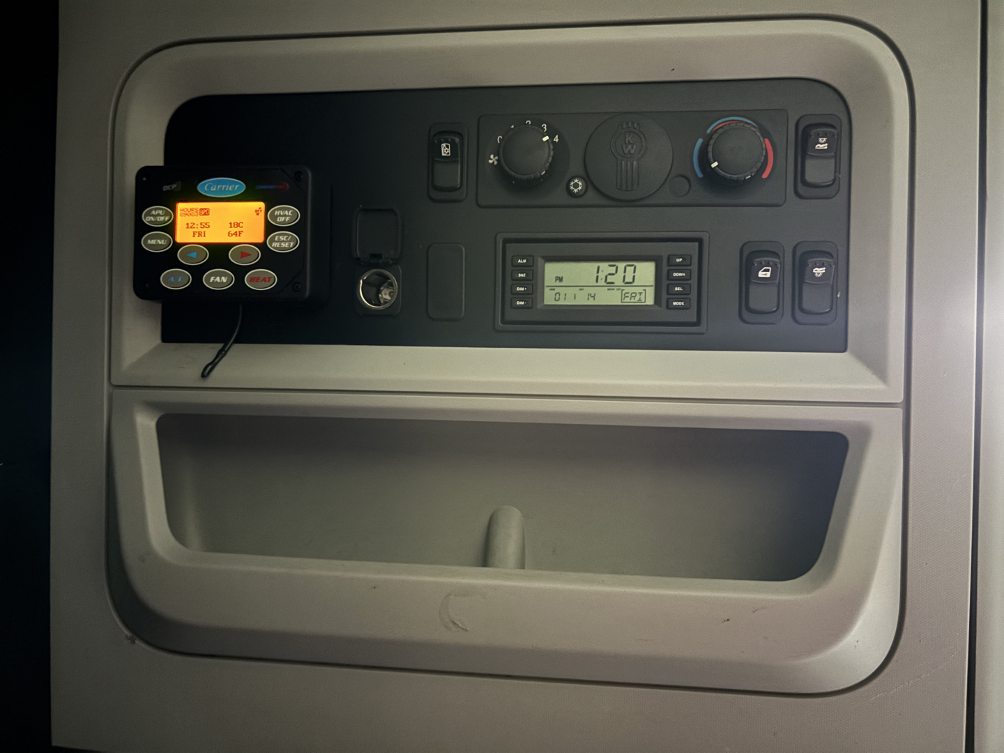 Kenworth T680 dash panel showing gauge cluster, control switches, and a digital display unit in the center console.
