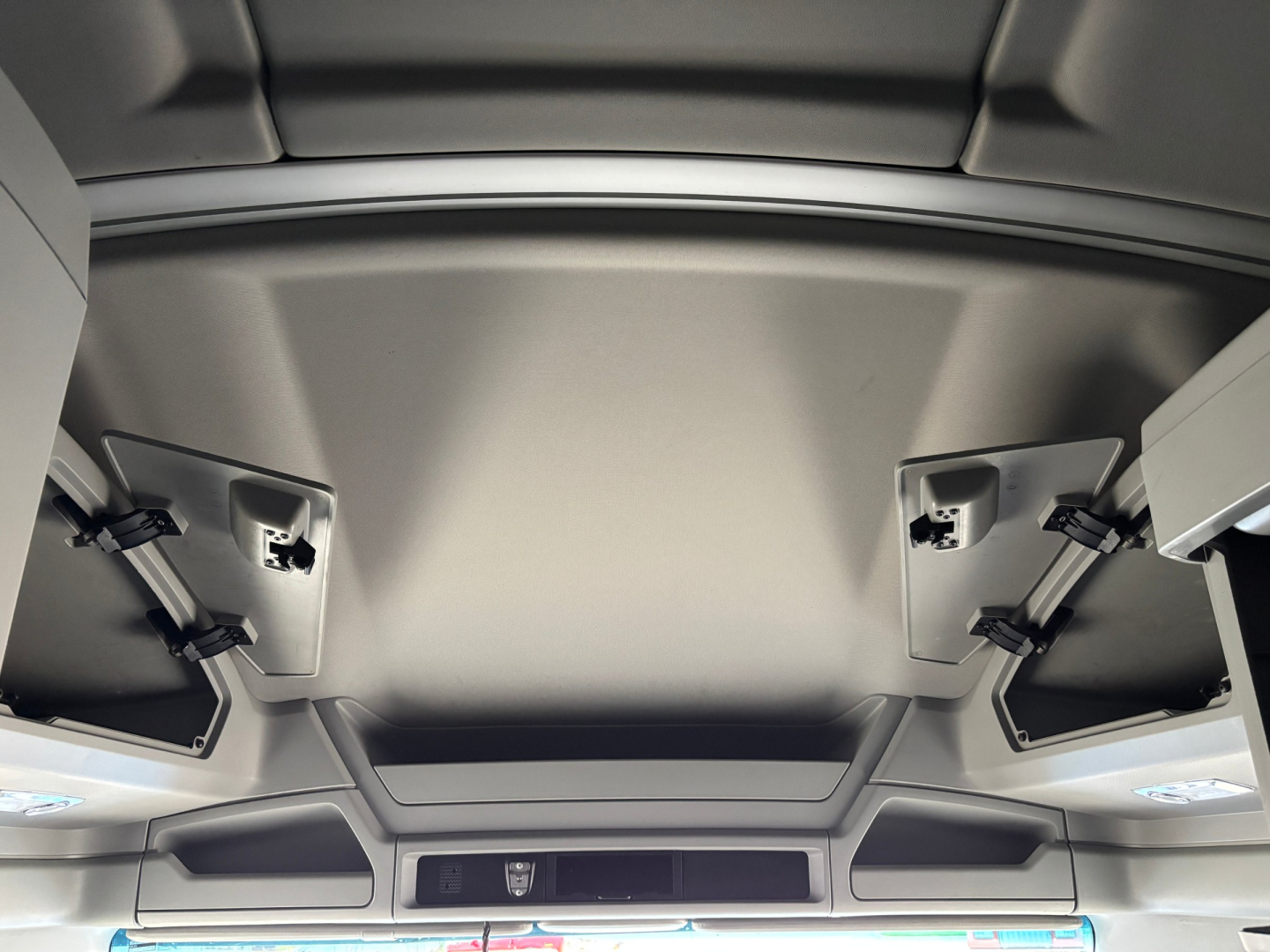 Kenworth T680 interior overhead area showing sun visors and folded storage compartments.