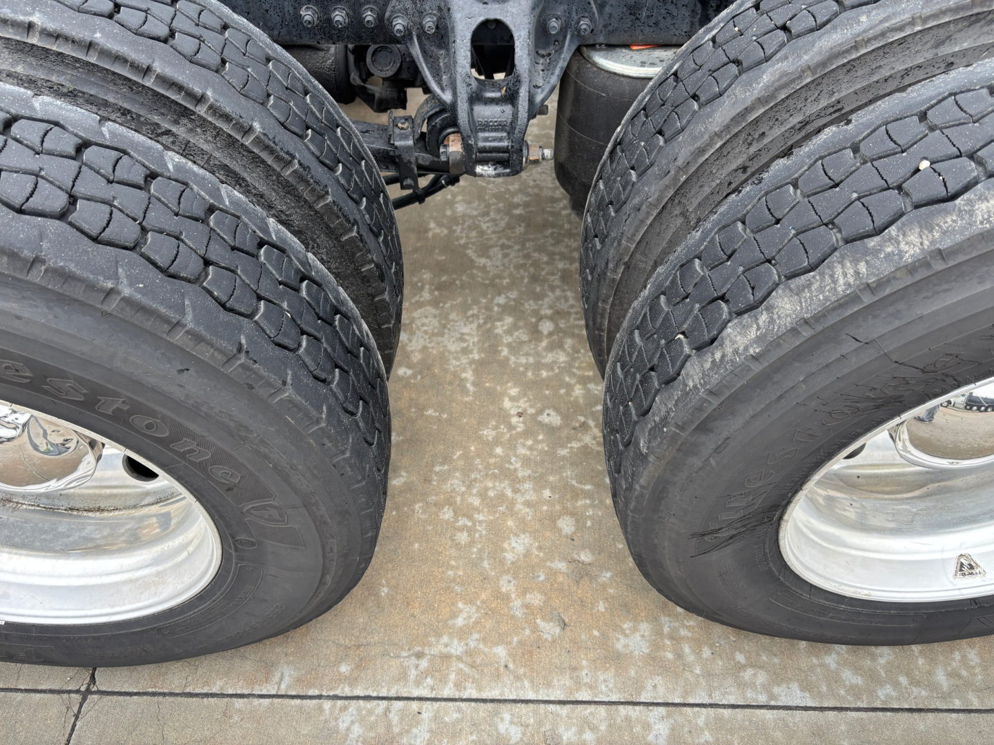 Kenworth T680 truck chassis showing tandem rear axles and dual tires with rims.