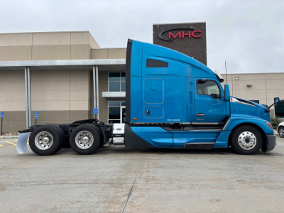 Kenworth T680 truck side view showing blue sleeper cab and dual rear axles.