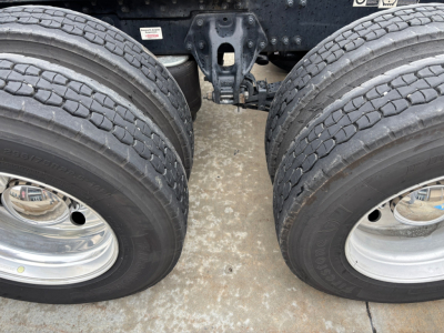 Dual rear wheels of a 2023 Kenworth T680 truck showing tires and axle assembly.