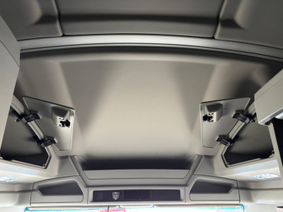 Kenworth T680 interior overhead area showing sun visors and folded storage compartments.