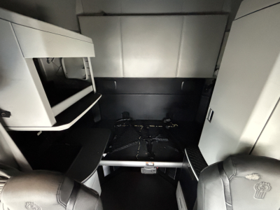 Kenworth T680 sleeper cabin interior showing storage shelves and under-bed area.