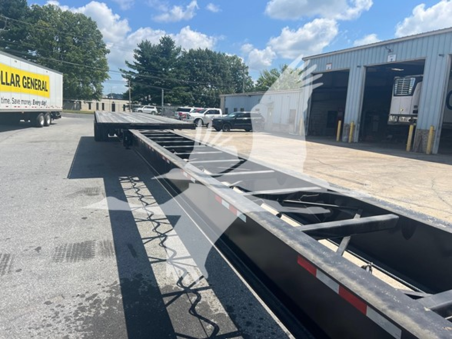 Manac spring extendable flatbed trailer inservice view showing long steel frame and extendable_sections.