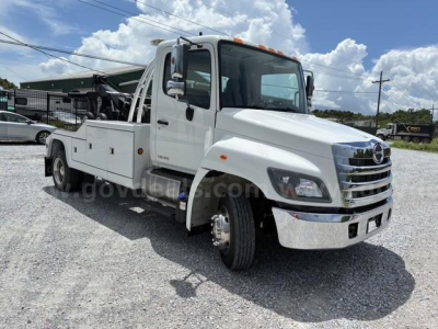 2018 Hino conventional cab tow truck showing front and side with white paint and chrome grille